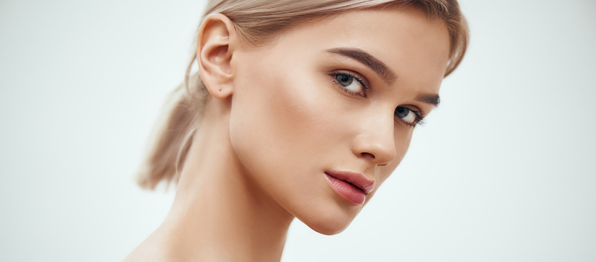 Bellevue hydrafacial model resting chin on her hand